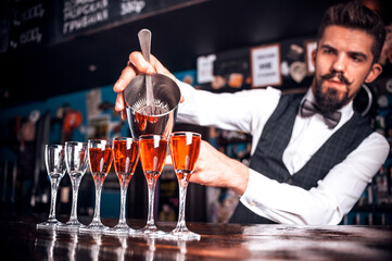 Professional barman creates a cocktail at bar