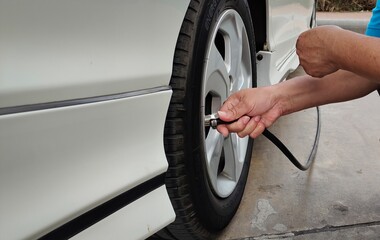 Men's hands are filling the tire.