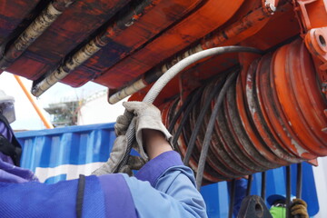 Worker hand grasp the Wire rope sling or cable sling to install crane reel drum for winch roll of...