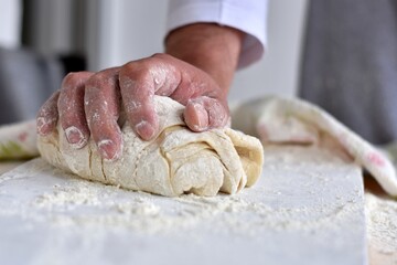 Bread making process. Closeup of man hands kneading dough. Baker cooking pastry. Culinary courses and food preparation.