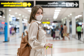 Asian woman wear masks while traveling at the airport terminal. New normal, covid19 disease...