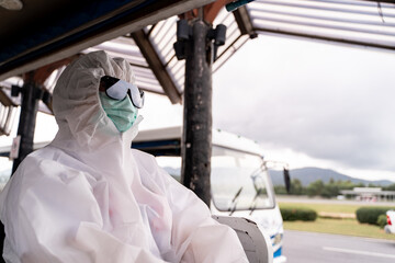 Person wearing protective suit , PPE with mask, sit on bus to entering airplane parking outside terminal in airport. during covid-19 virus pandemic , safety travel concept.