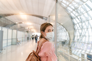 Asian woman wear masks while traveling at the airport terminal. New normal, covid19 disease prevention  concept.