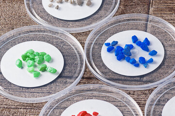 Piles of decorative stones for flower care on plastic lids close-up