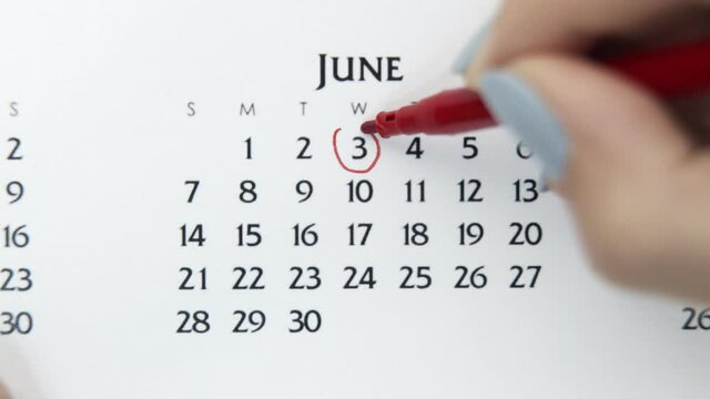 Female hand circle day in calendar date with a red marker. Business Basics Wall Calendar Planner and Organizer. June 3th