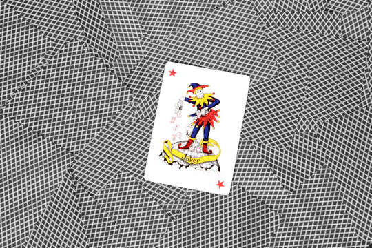 Top view of a joker playing card on scattered deck facedown as background