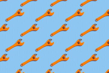Seamless regular pattern with adjustable wrench on a light blue background. Hard light. Father's...