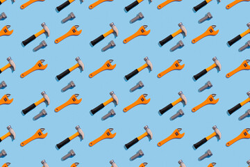 Seamless regular pattern with adjustable wrench, hammer and nut on a light blue background. Hard...