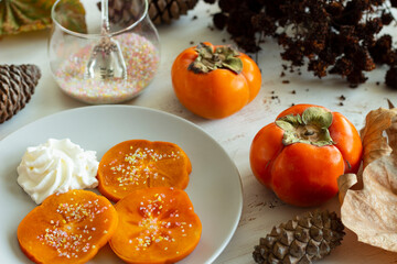 Fresh Persimmon dessert. Rainbow sugar. Cream.