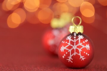 Christmas festive background.Red balls with a snowflake on a bright red glitter background with bright yellow bokeh. Christmas beautiful festive background. Holidays Beautiful wallpaper.