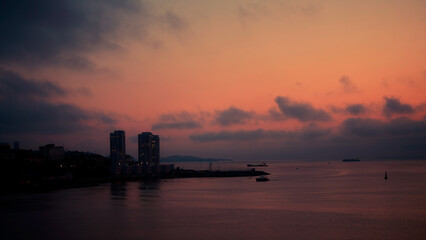 Naklejka premium beautiful view of the city beside ocean taken in dusk