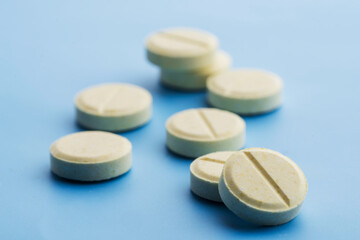 Pills are scattered on a blue background.