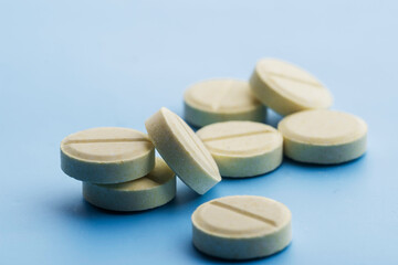 Pills are scattered on a blue background.