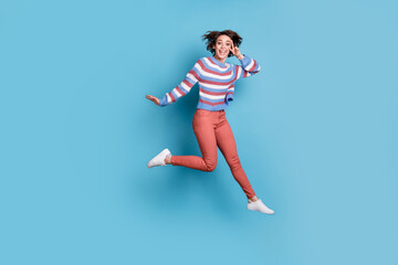 Full length body size photo of jumping high young girl showing gesture v-sign two fingers isolated on vibrant blue color background