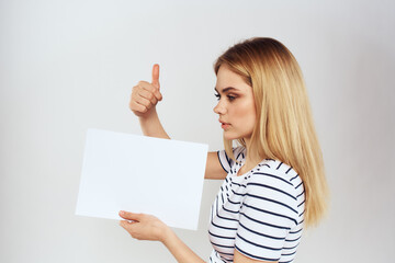 Naklejka premium woman holding a sheet of paper in her hands lifestyle striped t-shirt cropped view Copy Space