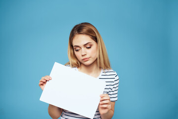 Naklejka premium Emotional woman holding a sheet of paper in her hands lifestyle close-up blue background Copy Space