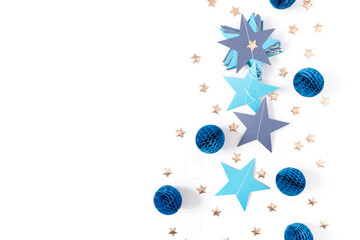 A garland of blue stars, honeycomb paper balls and golden stars are on a white background. Christmas, new year minimalistic template. Flat lay, top view, copy space.