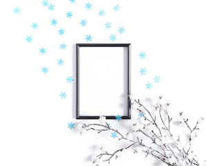 Modern winter layout made from blank black photo frame, snow covered branch and blue snowflakes. Minimalistic template for Christmas, New Year, invitation, banner. Flat lay, top view, copy space.