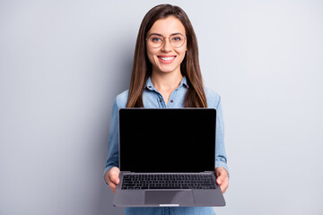 Photo of optimistic cute long hairdo lady show laptop wear spectacles blue shirt isolated on grey color background