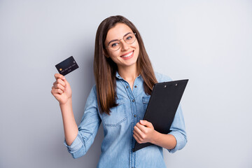 Naklejka premium Photo of pretty brown haired woman hold credit card clipboard wear denim shirt glasses isolated on grey color background