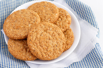Homemade shortbread cookies made of oatmeal are pile on white plate on the cloth background. Concept food healthy snack for enjoy in holiday.