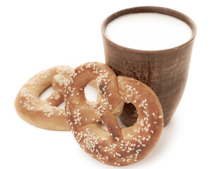 Tasty fresh just from oven crispy Brezel pretzel with brown ceramic glass of milk  isolated on white background retro style