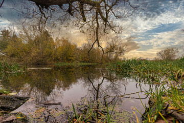 Reflections in a river with a dramatic sunset in the background. Picture from Scania county, Sweden