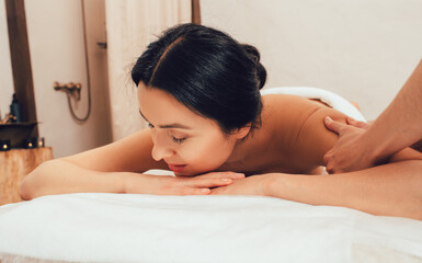 Beautiful woman getting a shoulder and body massage. Mixed race woman relaxing during massage