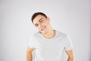 Obraz premium Man in a white t-shirt emotions gestures with hands close-up cropped view light background