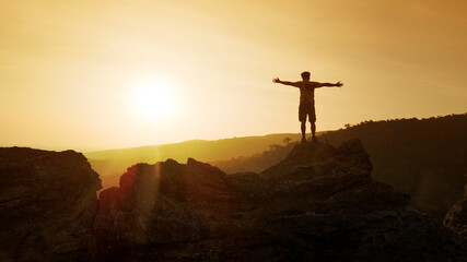 man open arms on top of mountain with sunset or sunrise background