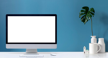 Mockup creative workspace with blank screen computer on white table and light blue wall.