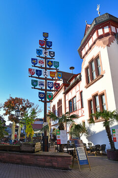 Lorsch, Germany - Traditional guild pole and part of old historic city hall building in front of blue sky