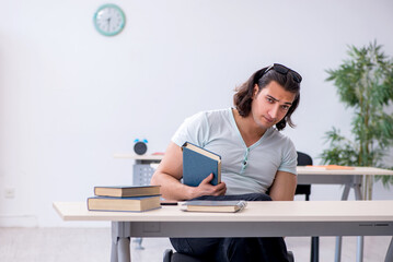 Young male student preparing for exam in the classroom