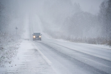 Car is driving on a winter road in a blizzard	