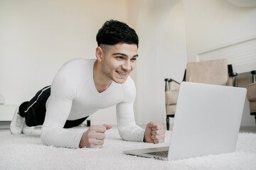 Healthy lifestyle a young man is quarantined in an apartment. home training sessions in front of a...