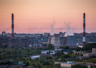 Fototapeta na wymiar Steam power plant pipes on sunset background