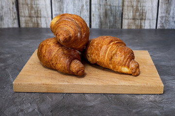 Fresh and tasty croissants, cutting board