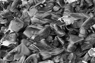 Old, discarded, leather, black military boots, in the trash