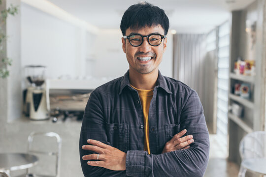 asian man portrait young male wear eye glasses smiling cheerful look thinking position with perfect clean skin posing on cafe background.fashion people life style concept