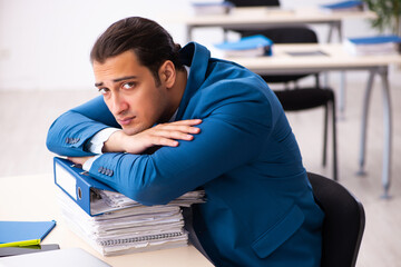 Young male employee unhappy with excessive work in the office