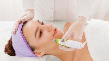 Fractional mesotherapy.A young beautiful woman in the cosmetologist’s office receives fractional...
