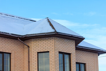 Snow on the roof of the house.