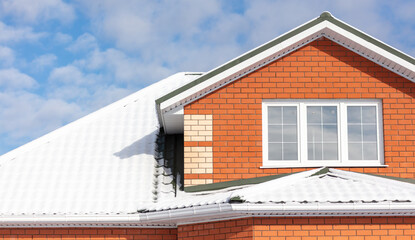 Snow on the roof of the house.