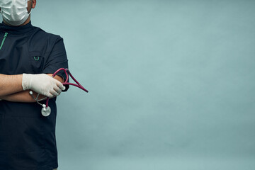 A young male doctor with protective gloves and a stethoscope. Professional clothing. Copy space.