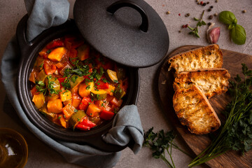 Cooked various chopped vegetables with herbs in a black cooking pot