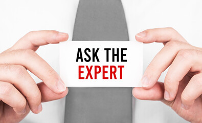 Businessman holding a card with text ASK THE EXPERT,business concept