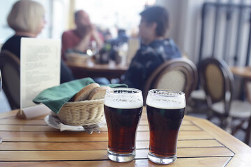 beer mug on a blurred background / beer restaurant beautiful dark beer in a mug in the interior of a pub