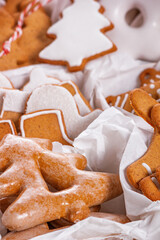 View of the unpacked christmas present with sweets inside white paper packaging, close-up with selective focus