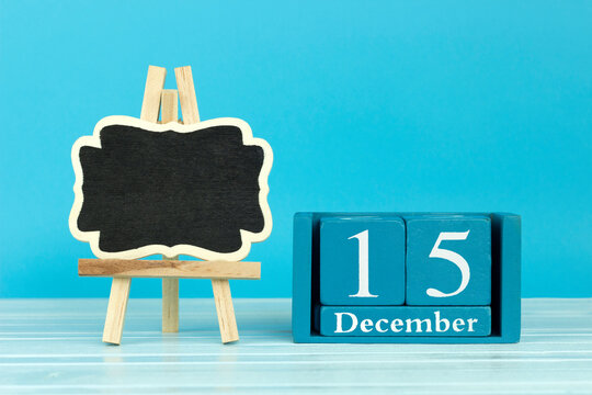 wooden calendar with the date of December 15 and an easel on a blue background, place for text, Zamenhof Day or International Esperanto Day; International Tea Day
