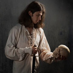 A romantic young man in a medieval costume with a sword says a Shakespearean monologue. - obrazy, fototapety, plakaty